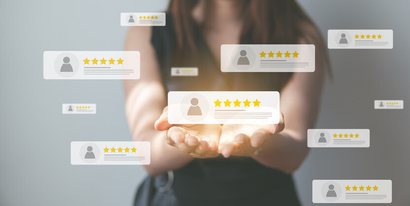 Woman holding glowing reviews with five-star ratings floating around her.