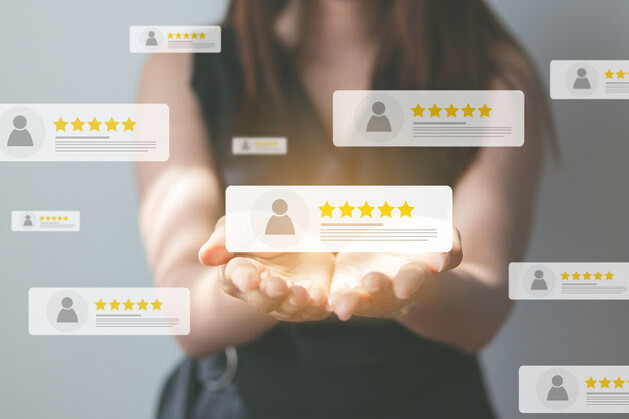 Woman holding glowing reviews with five-star ratings floating around her.