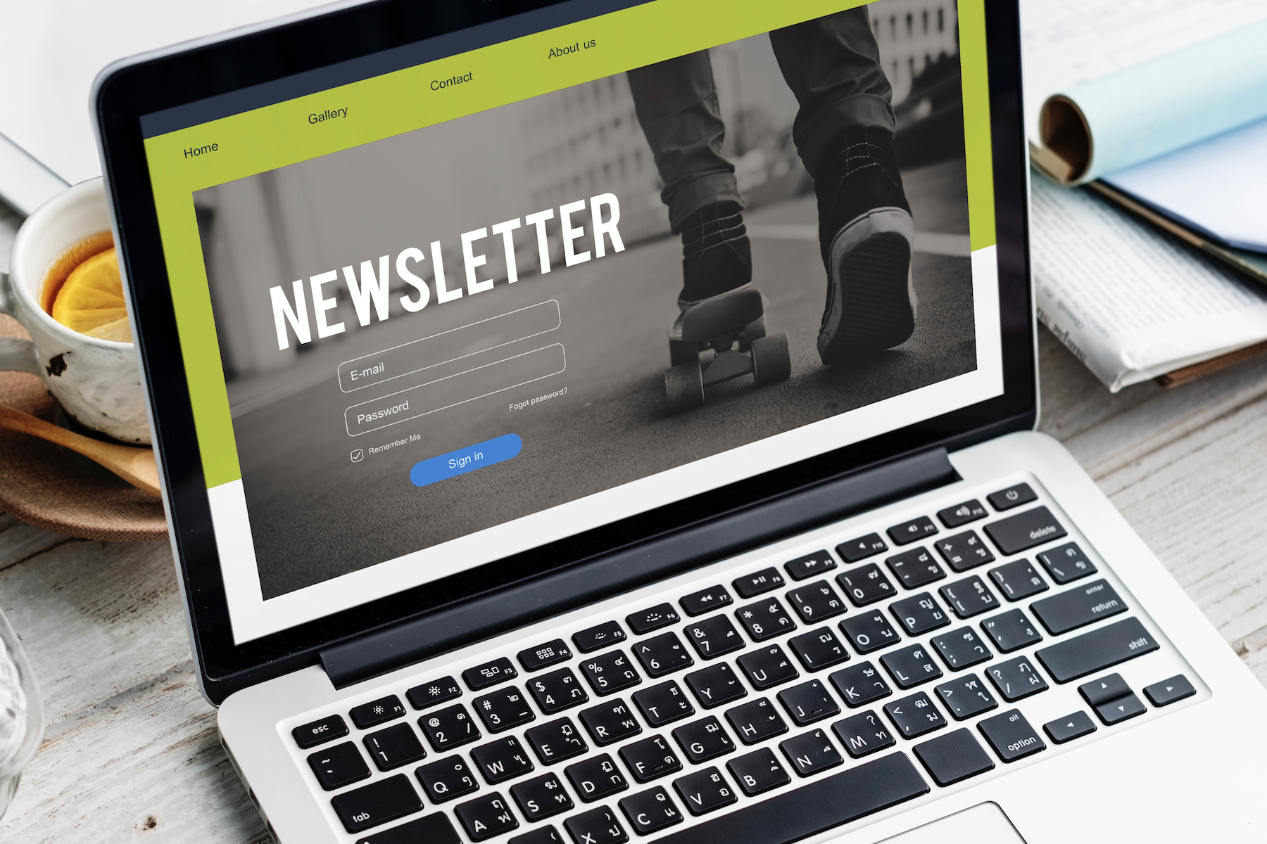 Laptop on desk displaying newsletter signup webpage and navigation menu