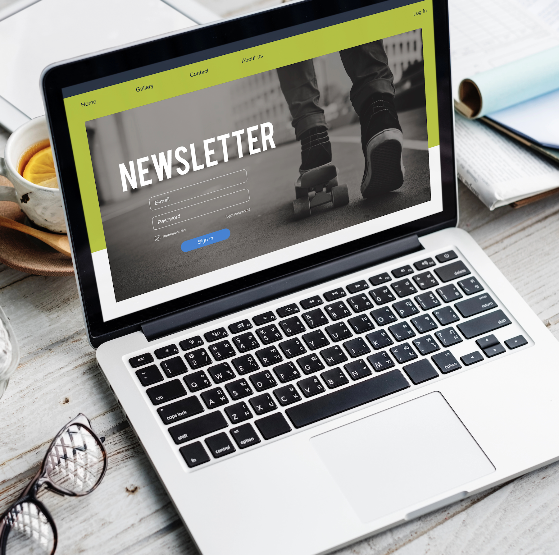 Laptop on desk displaying newsletter signup webpage and navigation menu