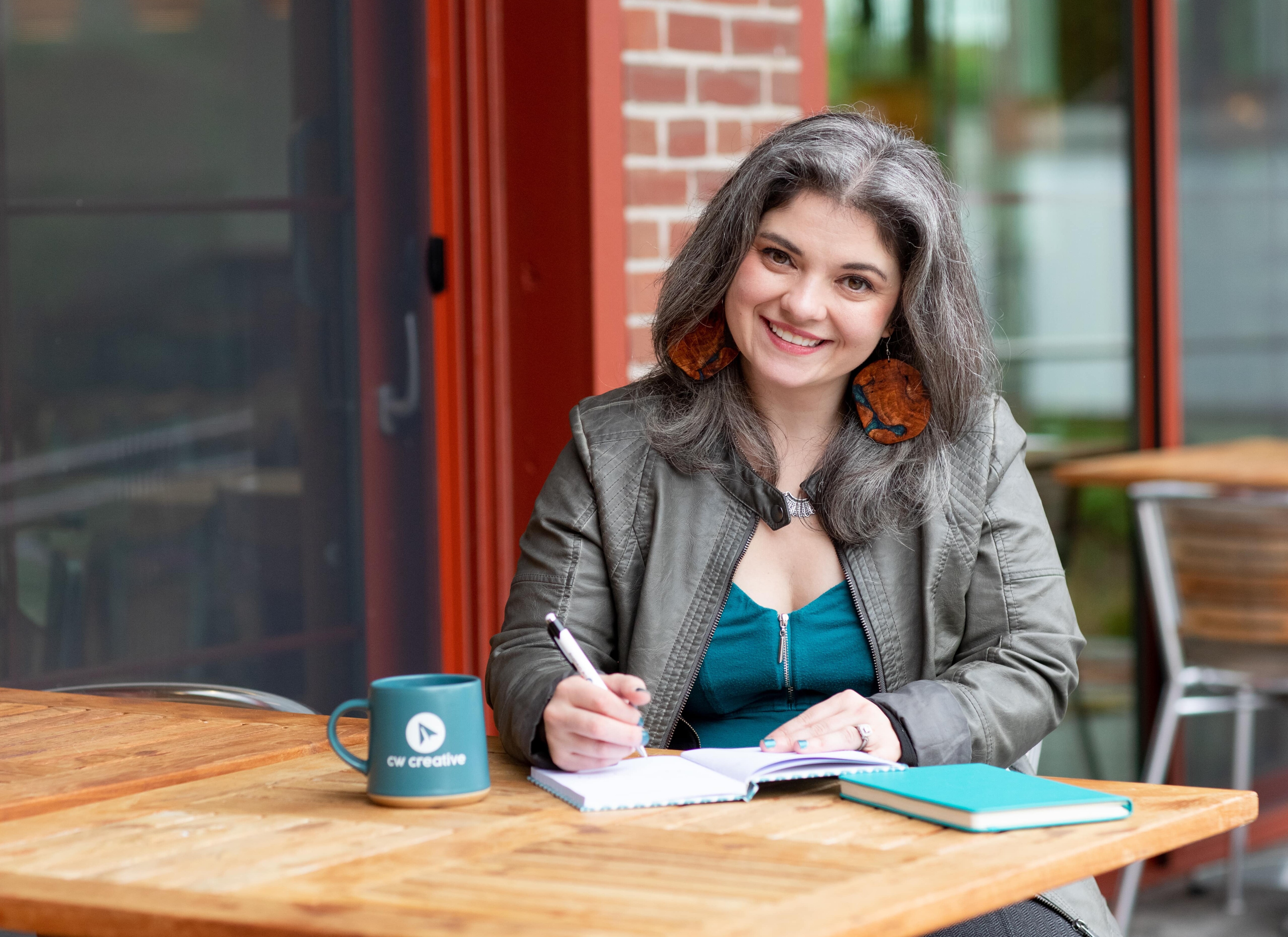 Mollie Lannen sitting at a table with CW Creative coffee cup