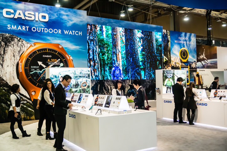 booth at trade show featuring attendees viewing products.