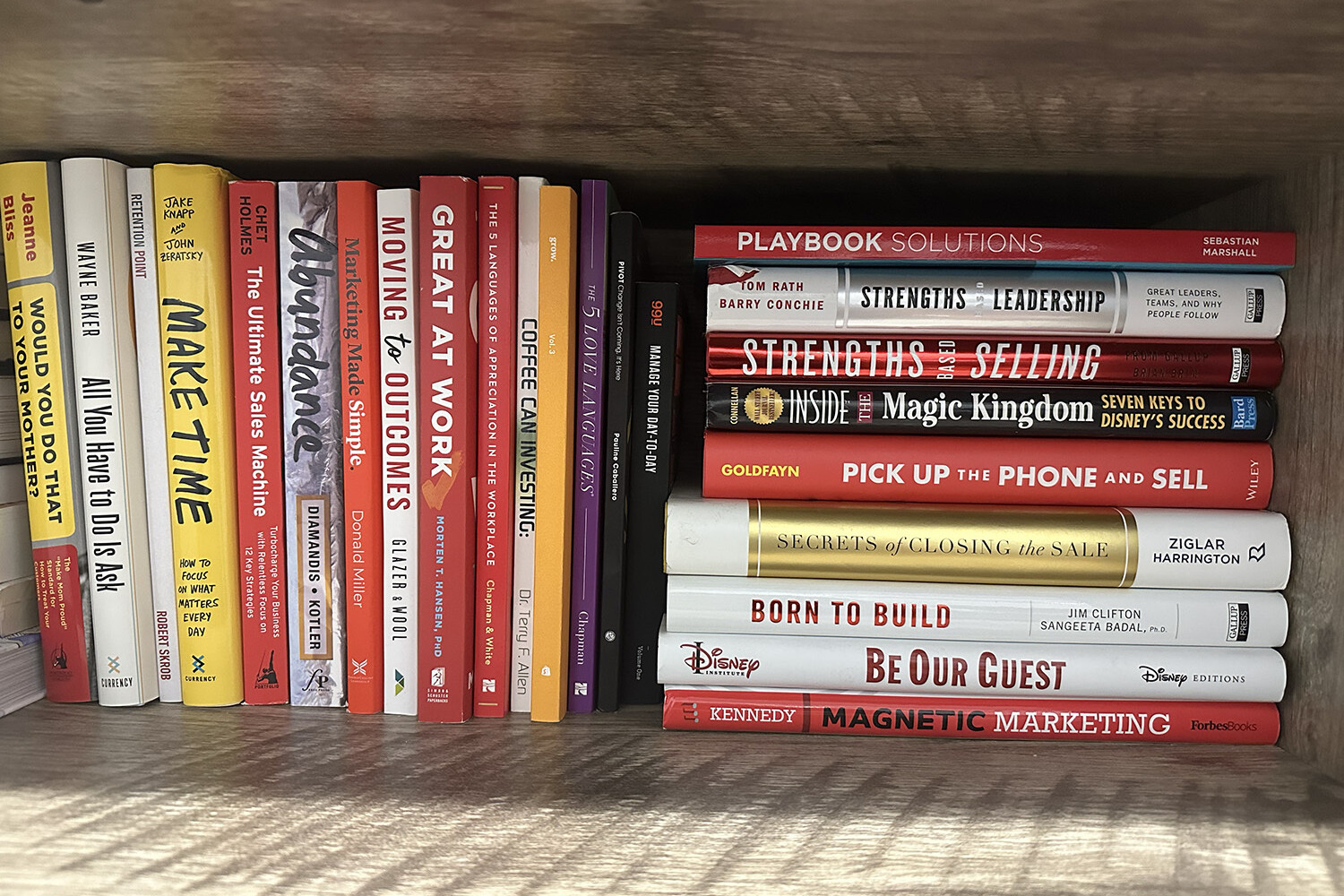 Organized bookshelf with titles on sales, leadership, and productivity.