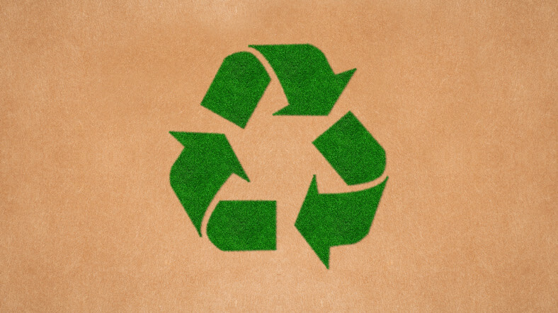 Green recycling symbol on brown cardboard background, representing sustainability and eco-friendly practices