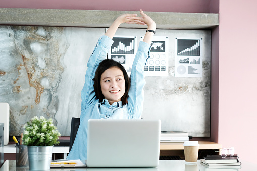 healthy employees - woman stretching at desk